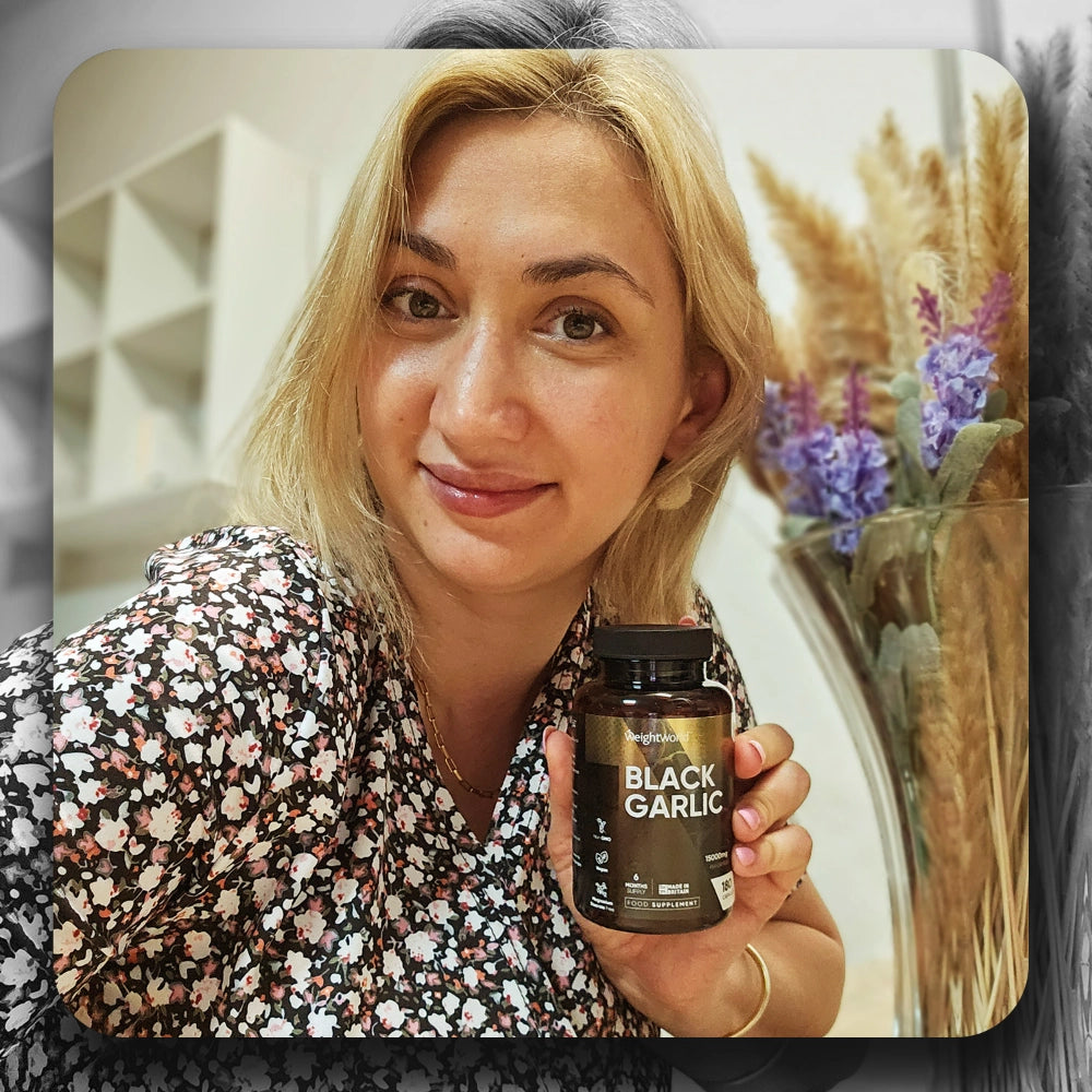 Person holder WeightWorld BLACK GARLIC flaske, nærbillede