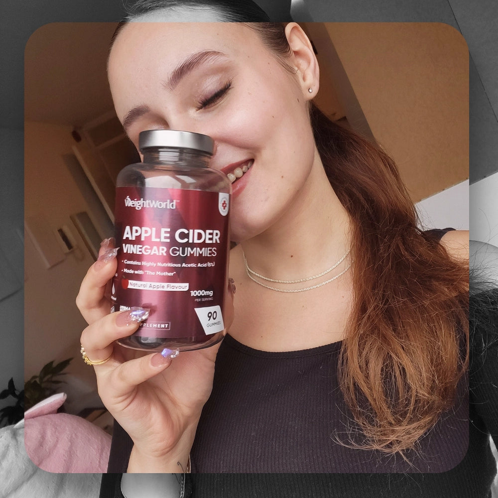 Glasflaske med WeightWorld æblecidereddike vingummier holdt i hånden